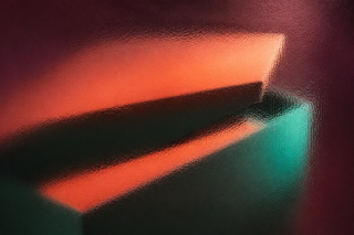 Unbranded rigid presentation box seen through full-frame smoked pebbled glass in plum, coral and teal light.