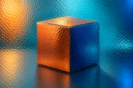 Unbranded small square cosmetic carton behind textured glass in vivid coloured light.
