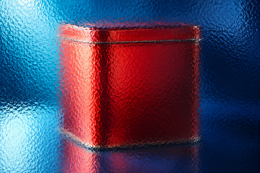 Unbranded square food tin behind textured glass in vivid coloured light.