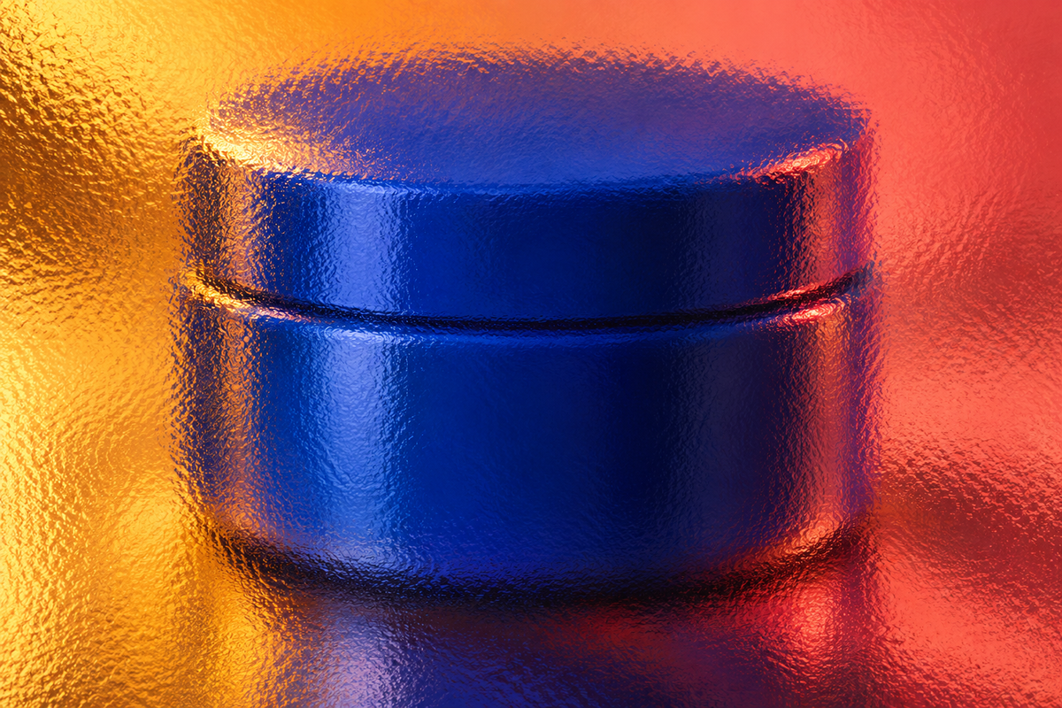 Unbranded cobalt-blue cosmetic jar with fitted lid seen through full-frame textured glass in coral and amber light.