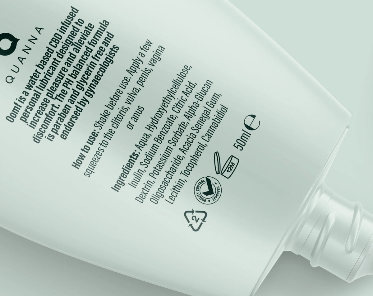 Close-up of the OOMF bottle dispensing neck and Quanna back-label typography, instructions and recycling symbols.