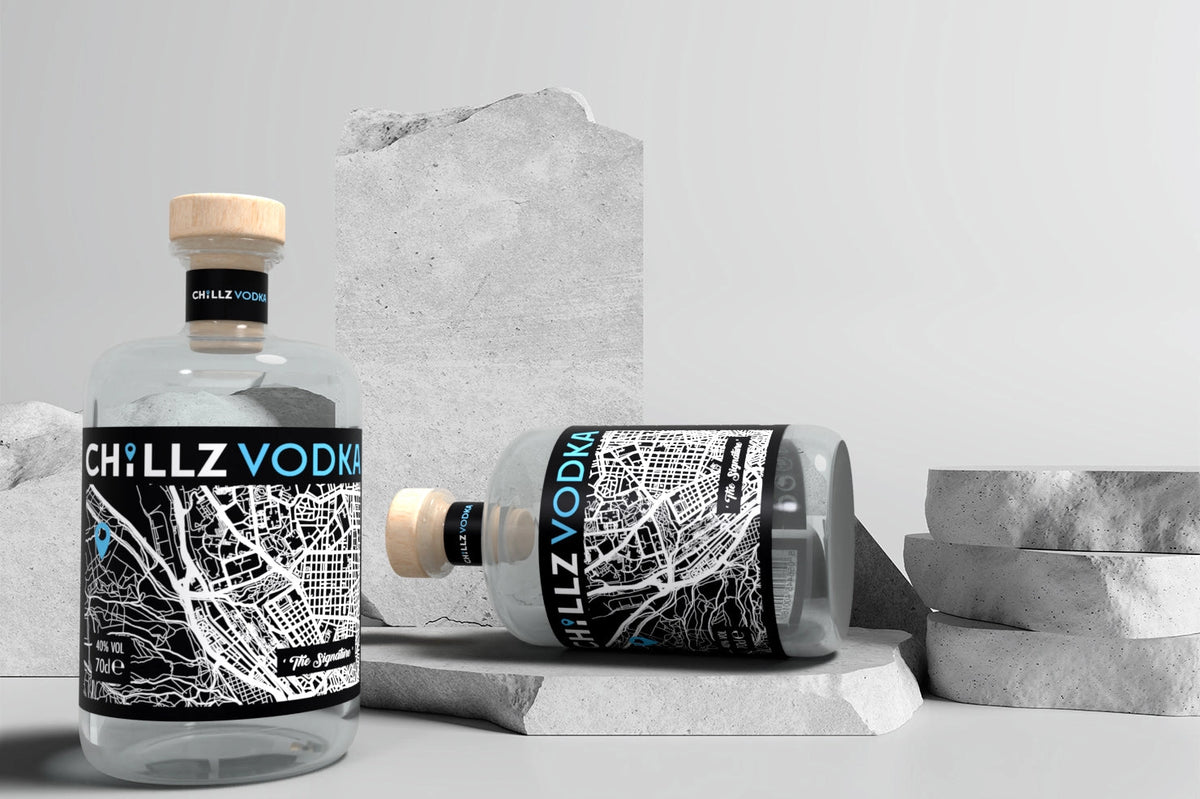 Two CHILLZ VODKA bottles on concrete blocks showing the monochrome map label and blue flavour typography.