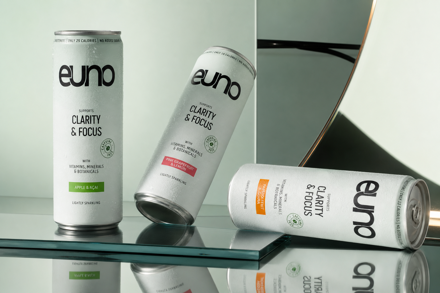 Three Euno caffeine-free functional drink cans photographed on polished chrome in a minimalist fashion editorial composition