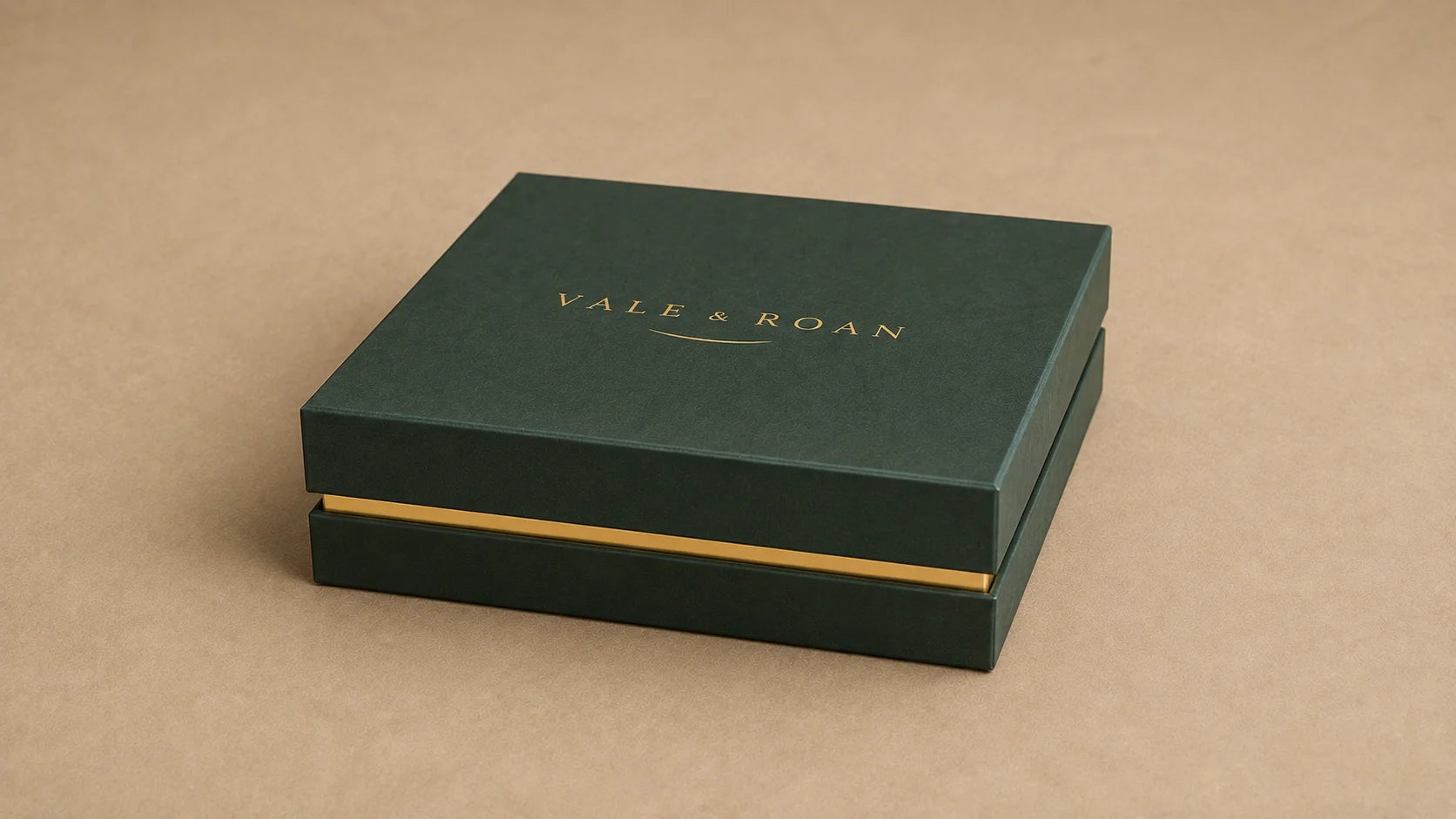 Closed dark green Vale & Roan dog collar presentation box with a gold wordmark on a warm beige surface